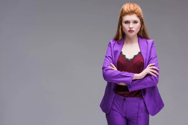 Young stylish female model dressed in purple suit isolated on grey — Stock Photo
