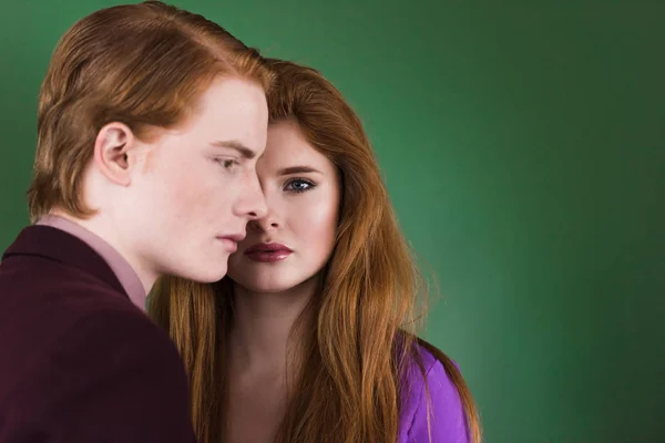 Side view of young male model with girlfriend near isolated on green — Stock Photo