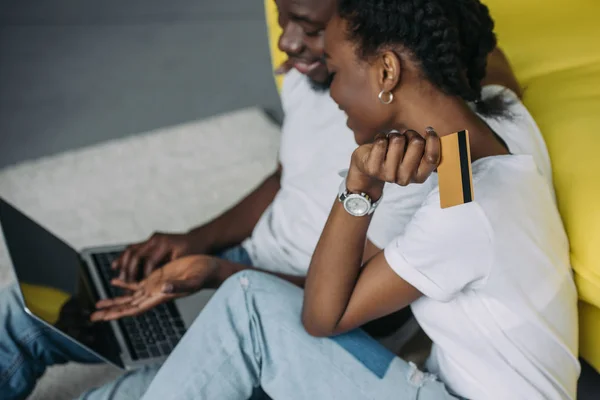 Ritagliato colpo di sorridente giovane coppia afroamericana con computer portatile e carta di credito shopping online — Foto stock