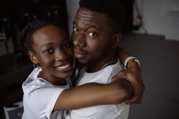 Belo jovem casal afro-americano abraçando e sorrindo para a câmera — Fotografia de Stock