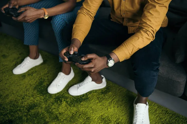 Foto cortada de casal afro-americano brincando com joysticks juntos em casa — Fotografia de Stock