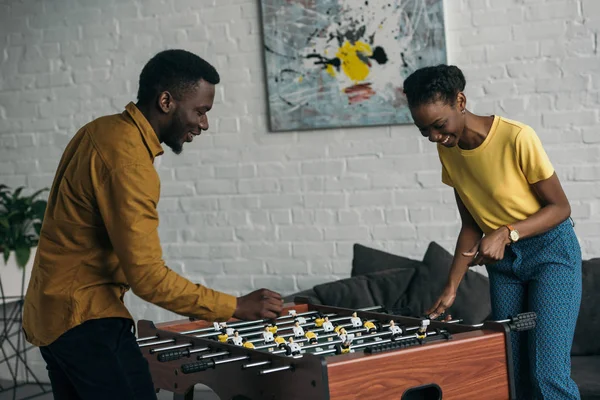 Glückliches junges afrikanisch-amerikanisches Paar spielt gemeinsam Fußball — Stockfoto