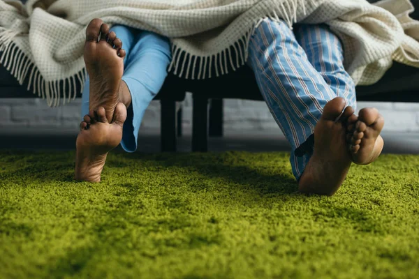 Plan recadré de couple afro-américain pieds nus en pyjama passer du temps ensemble à la maison — Photo de stock