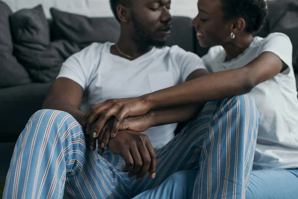 Cropped shot of beautiful young african american couple in pajamas smiling each other at home — Stock Photo