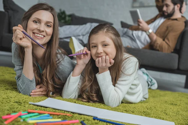 Mother and daughter drawing on floor and looking at camera — Stock Photo