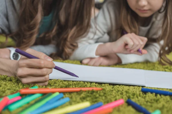 Immagine ritagliata di madre e figlia che disegnano sul pavimento con pennarelli — Foto stock