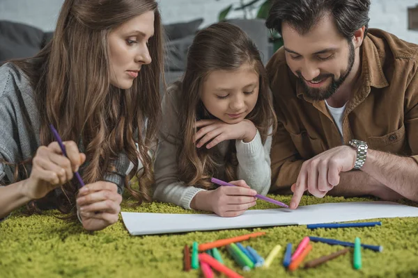 Happy father pointing on something in album to daughter — Stock Photo