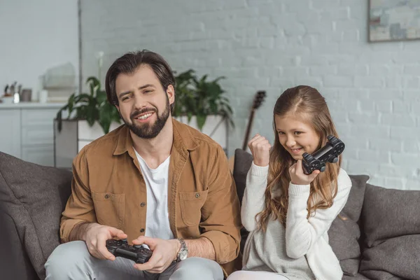 Fille gagnant père dans le jeu vidéo à la maison — Photo de stock