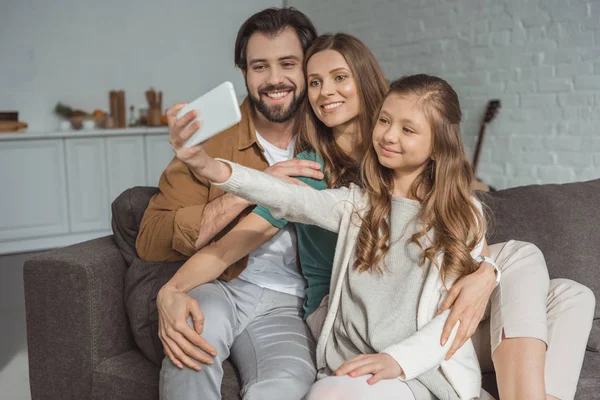 Happy parents and daughter taking selfie with smartphone — Stock Photo