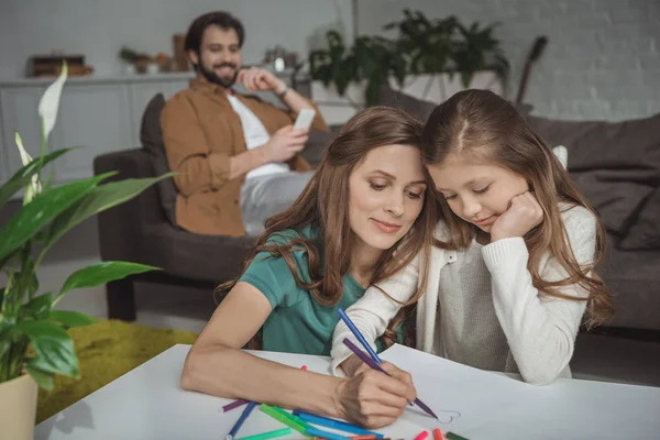 Madre aiutare figlia disegno con pennarelli a casa — Foto stock