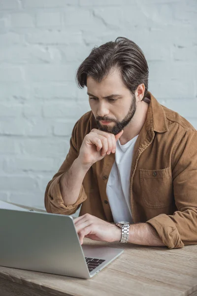 Homem de negócios bonito usando laptop no escritório — Fotografia de Stock