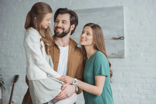 Pais felizes olhando para filha adorável — Fotografia de Stock