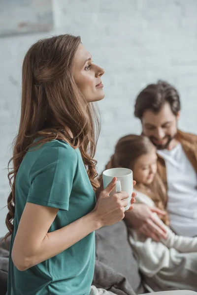 Vista laterale della madre che tiene la tazza di caffè — Foto stock