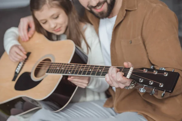 Imagem recortada de pai ensinando filha tocando guitarra acústica — Fotografia de Stock