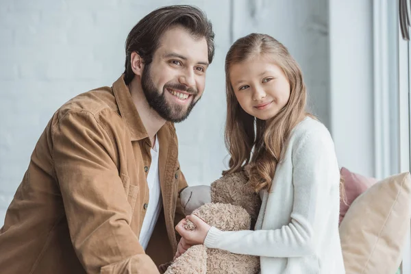 Happy father and daughter looking away at window — Stock Photo