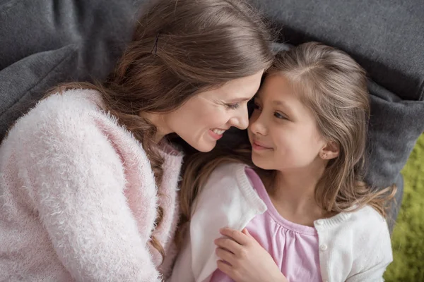 Blick aus der Vogelperspektive auf glückliche Mutter und Tochter, die auf dem Sofa liegen und sich zu Hause anschauen — Stockfoto