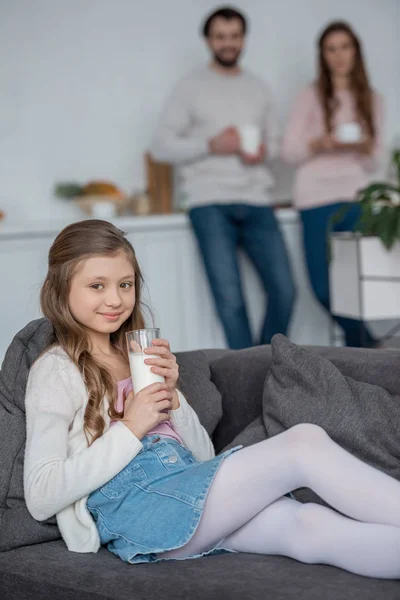 Adorável filha segurando copo de leite em casa — Fotografia de Stock