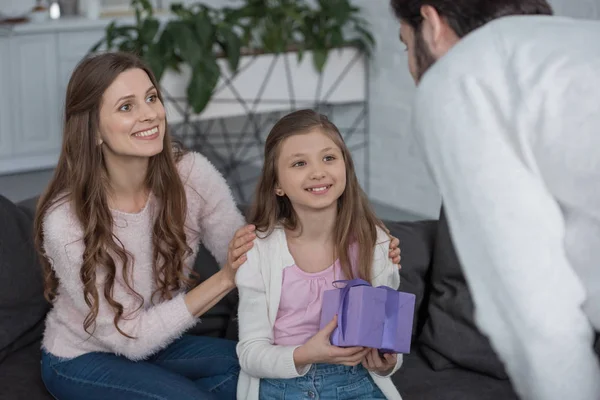 Hija presentando caja de regalo a padre en casa - foto de stock