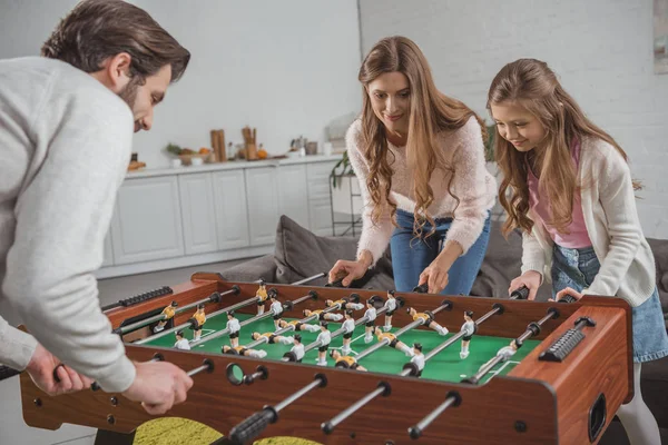 Parents and daughter playing table football at home — Stock Photo