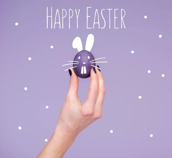 Huevo de Pascua en la mano femenina con letras de pascua feliz - foto de stock