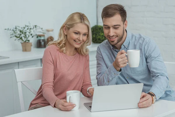 Retrato de mãe e filho crescido usando laptop em casa — Fotografia de Stock