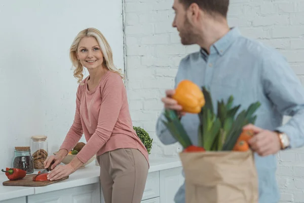 Selektiver Fokus der lächelnden Mutter und des erwachsenen Sohnes beim gemeinsamen Kochen zu Hause — Stockfoto