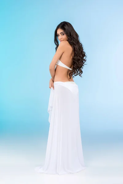 Jovem morena bronzeada de biquíni posando com véu branco, isolada em azul — Fotografia de Stock