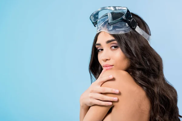 Attractive tanned girl posing in goggles, isolated on blue — Stock Photo