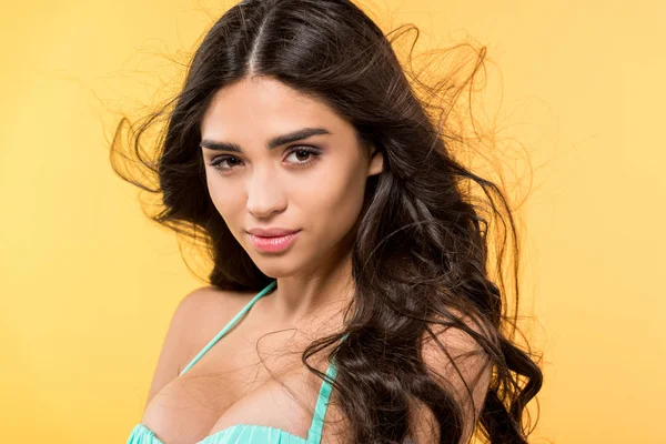 Schöne gebräunte Brünette posiert im Bikini, isoliert auf gelb — Stockfoto