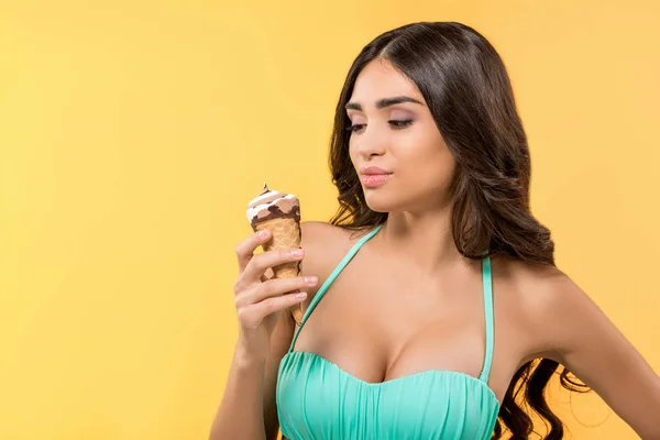 Menina atraente posando em biquíni com cone de sorvete, isolado em amarelo — Fotografia de Stock