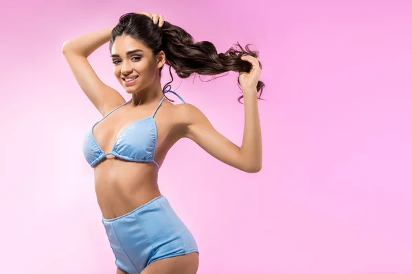 Attractive cheerful girl posing in trendy blue bikini, isolated on pink — Stock Photo