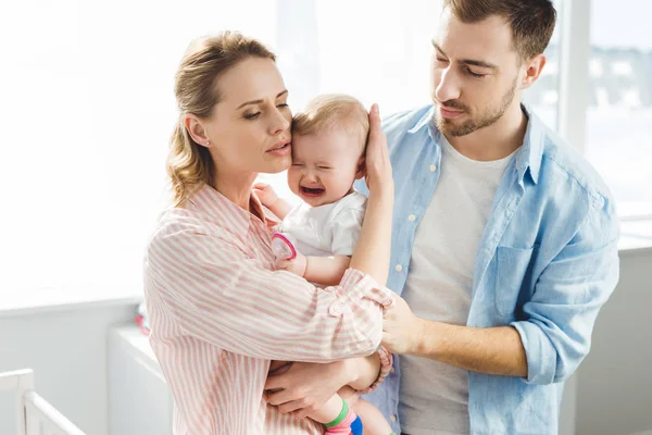 Parents trying to calm down crying infant daughter — Stock Photo