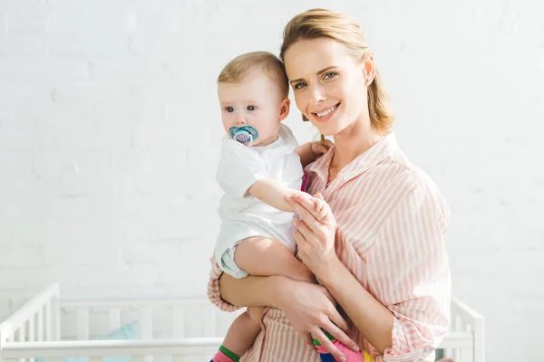 Sorridente madre che tiene la figlia neonata con manichino bambino — Foto stock