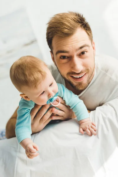 Junger Vater hält kleine Tochter mit Babyattrappe — Stockfoto