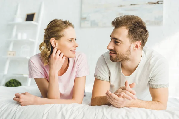 Smiling young caucasian couple in bed — Stock Photo