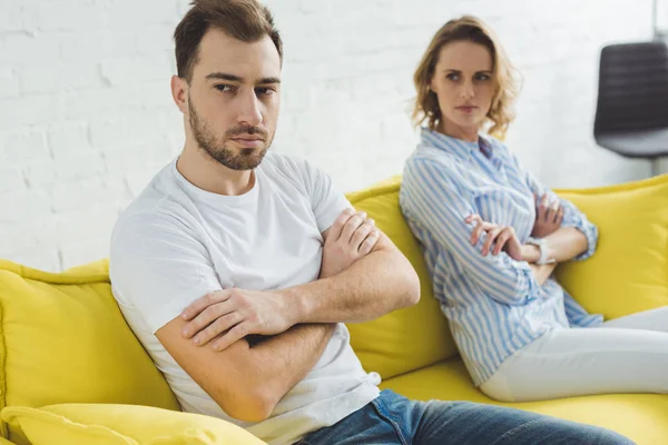 Young upset couple sitting on couch after argue — Stock Photo