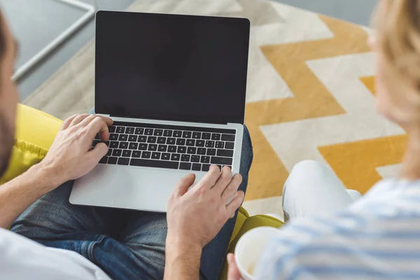 Vista posteriore della giovane coppia seduta con laptop con schermo vuoto — Foto stock