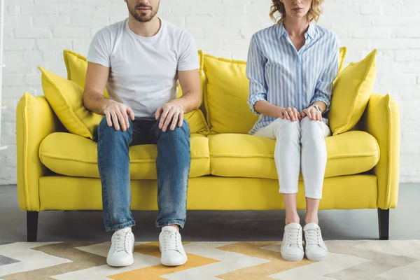 Cropped image of young couple sitting on couch in modern room — Stock Photo