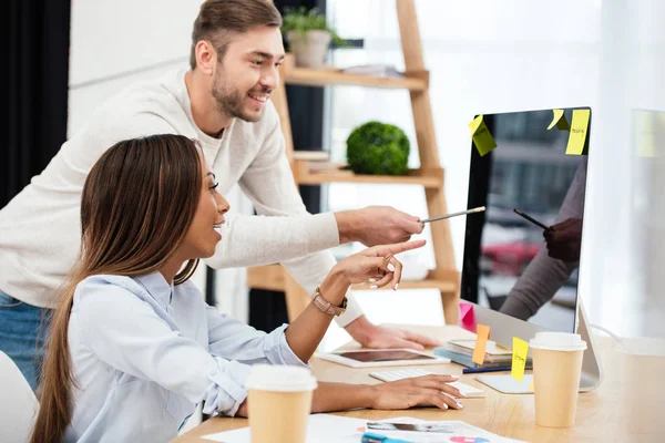 Vista laterale di uomini d'affari multietnici che discutono la nuova strategia di marketing sul posto di lavoro in ufficio — Foto stock