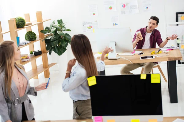 Empresarias multiculturales mirando a su colega en el lugar de trabajo en la oficina — Stock Photo
