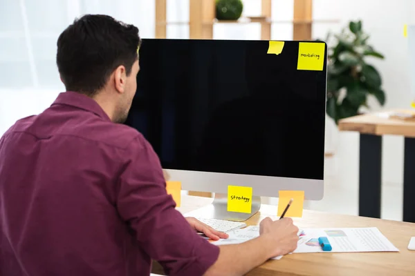 Частковий погляд бізнесмена, який працює на комп'ютері на робочому місці в офісі — стокове фото