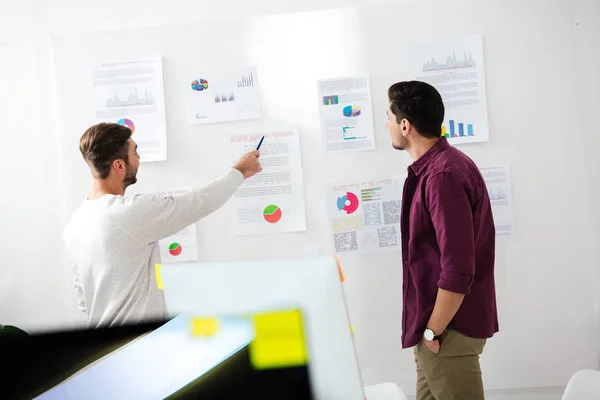 Visión de fondo de los jóvenes empresarios discutiendo nueva estrategia de marketing en el cargo - foto de stock