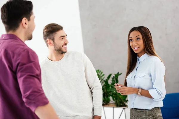 Smiling multiethnic business colleagues having conversation in office — Stock Photo