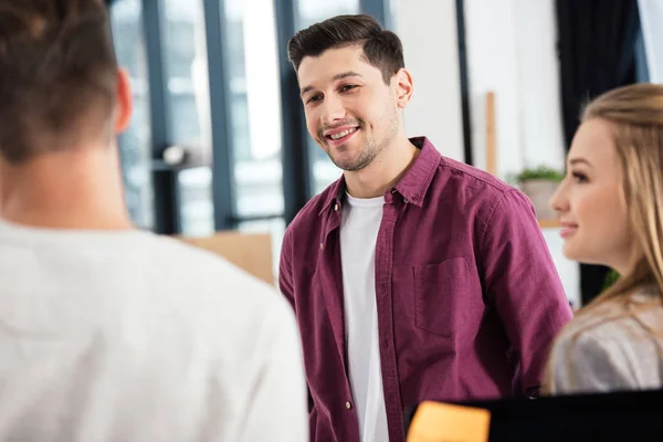 Focus selettivo del giovane imprenditore che ha una conversazione con i colleghi in carica — Stock Photo