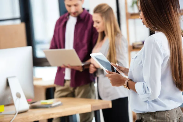 Selective focus of young african american businesswoman using tablet in office — Stock Photo