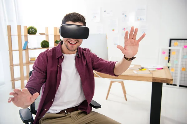 Porträt eines lächelnden Marketing Managers im Virtual-Reality-Headset am Arbeitsplatz im Büro — Stockfoto