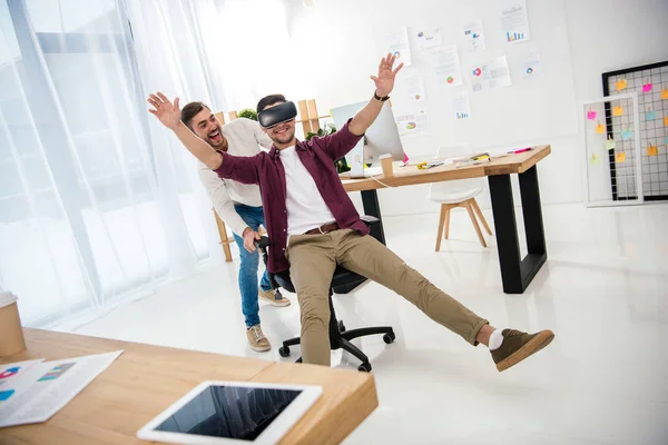 Cheerful businessman in vr headset with colleague near by in office — Stock Photo
