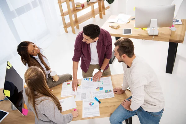 Visión general de colegas de negocios multiétnicos discutiendo un nuevo proyecto de marketing en el lugar de trabajo en la oficina - foto de stock