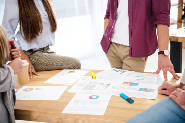 Cropped shot of multiethnic business colleagues discussing new marketing project at workplace in office — Stock Photo