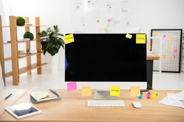 Vue rapprochée du lieu de travail avec écran d'ordinateur vierge et notes collantes dans le bureau — Photo de stock